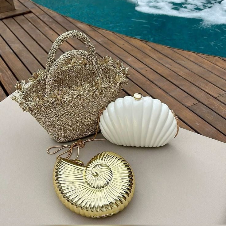 Gold woven conch-shaped handbag with floral accents, perfect for beach outings or summer events.
