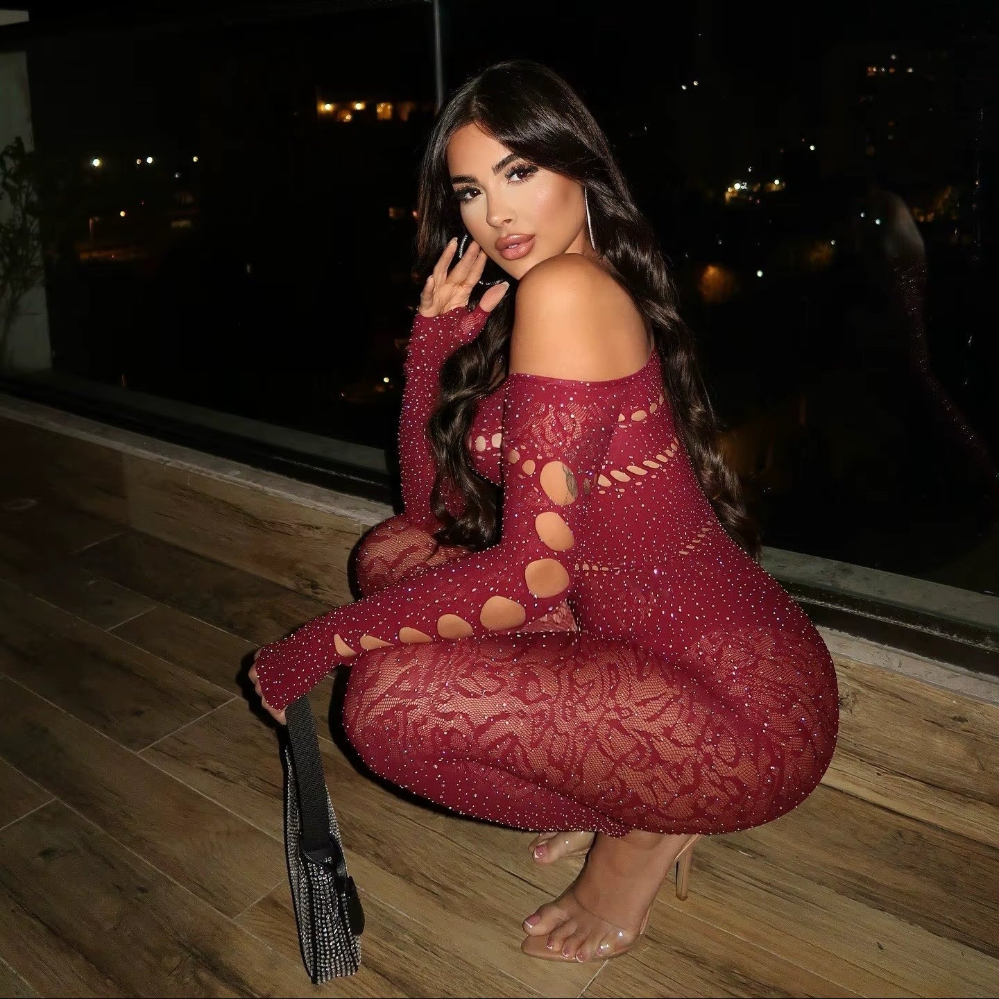 Woman in a red dress sitting on a rooftop at night