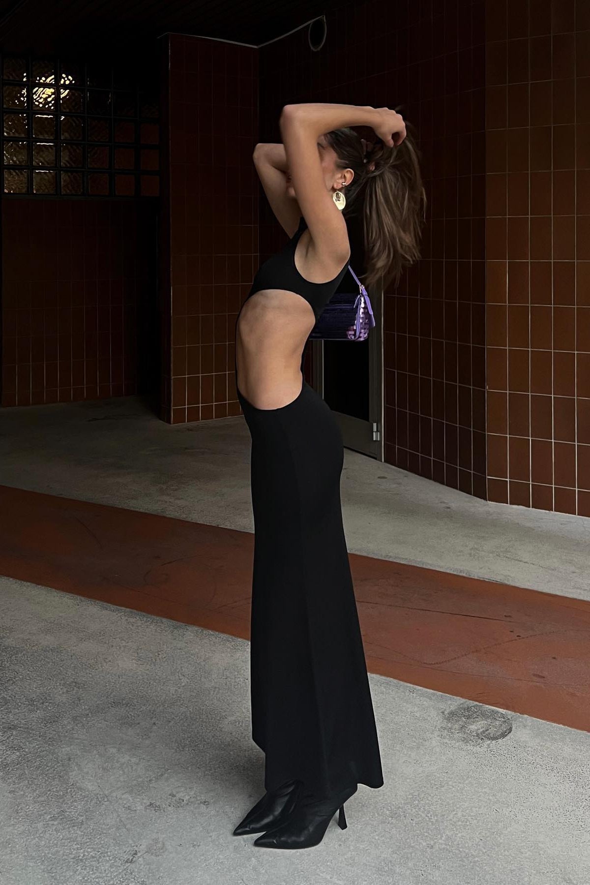 Black stretch maxi dress with high neckline and dramatic hourglass cut-out, close-up