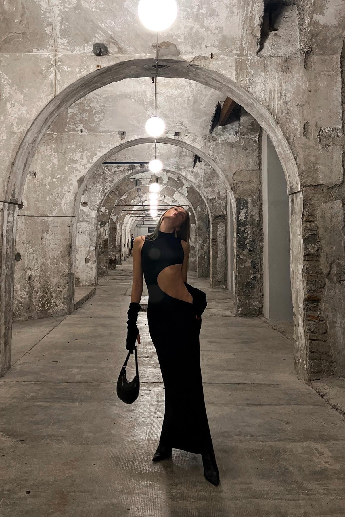 Model in black sleeveless cut-out maxi dress, three-quarter angle view