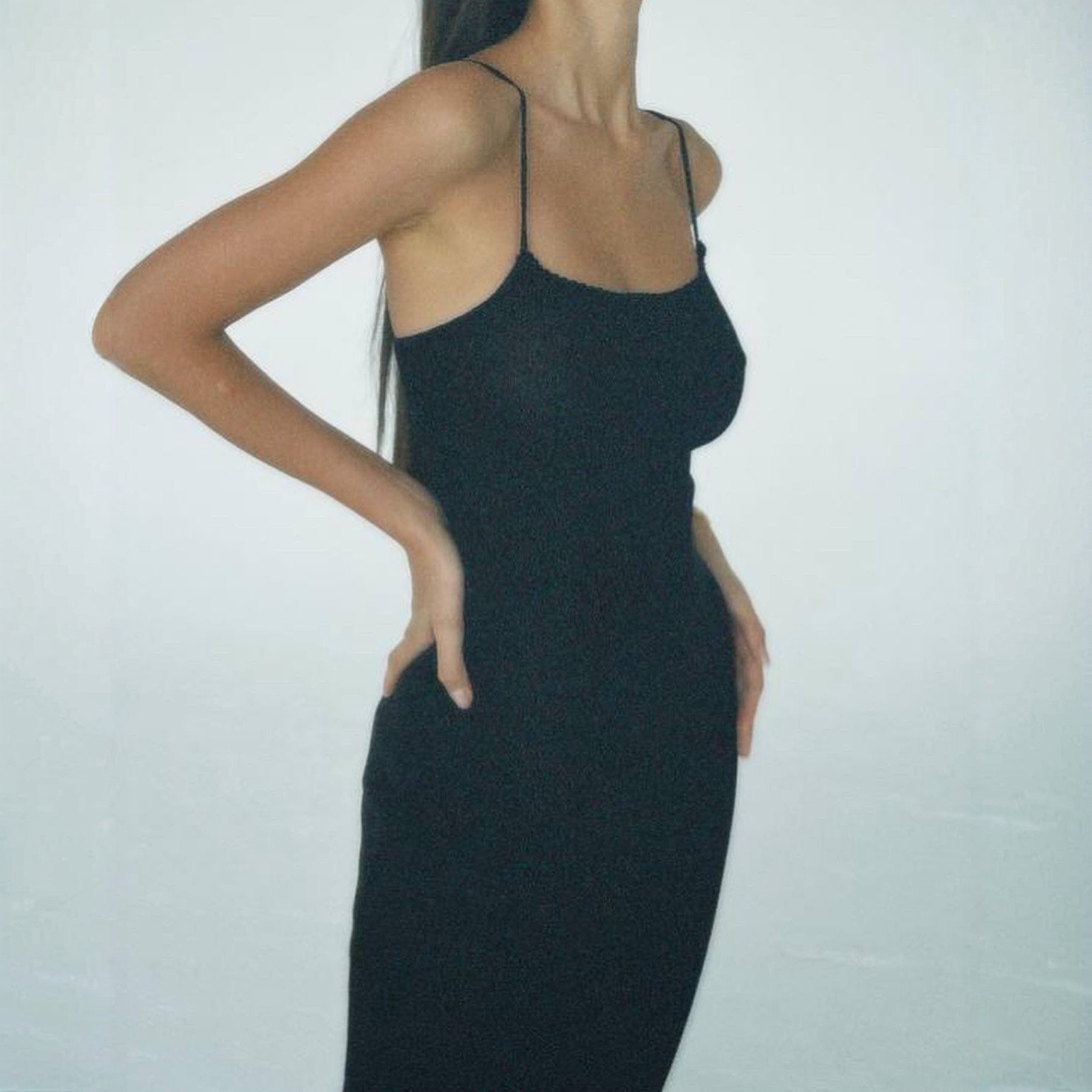 Black dress worn by a person on a plain background