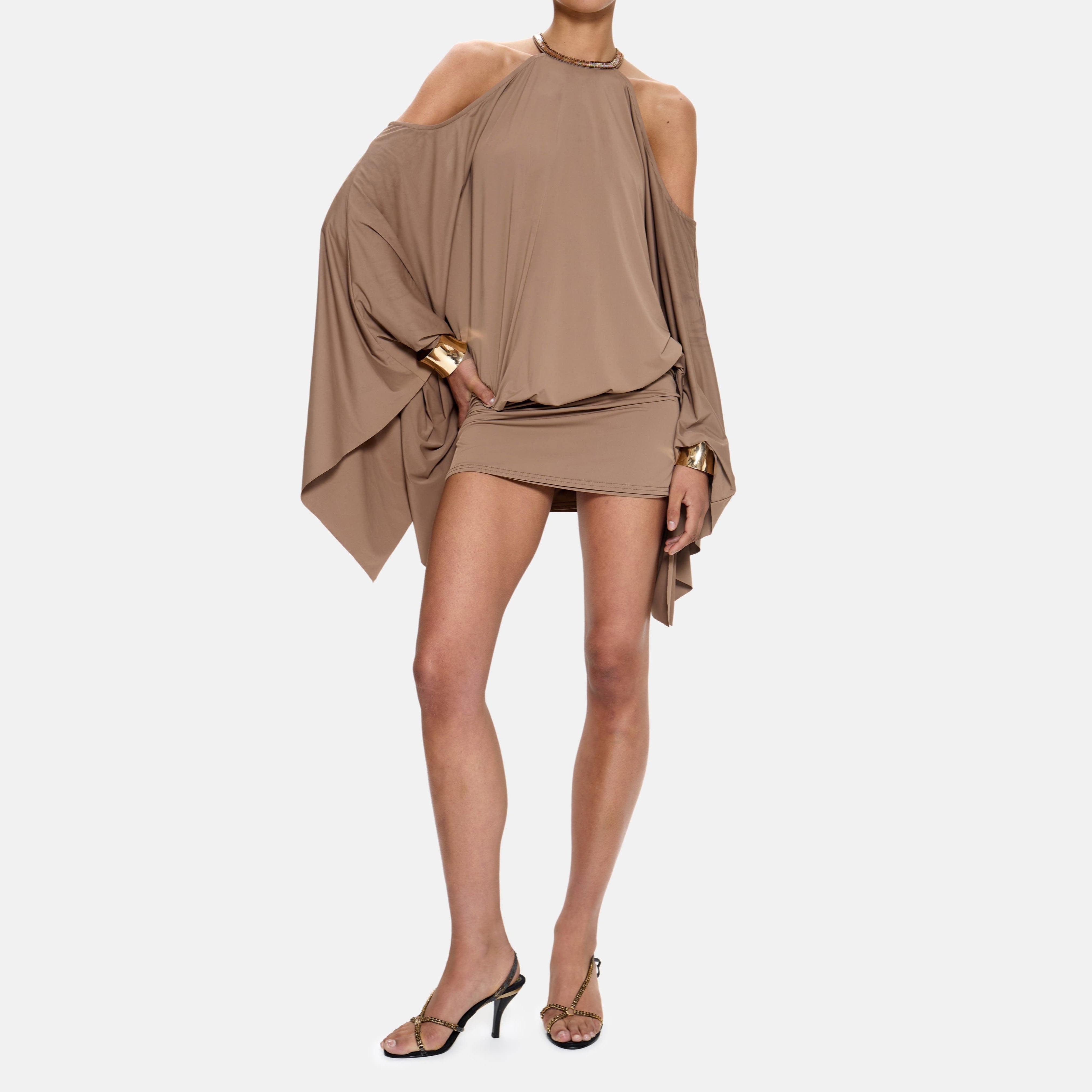 Woman wearing a beige dress with a plain background