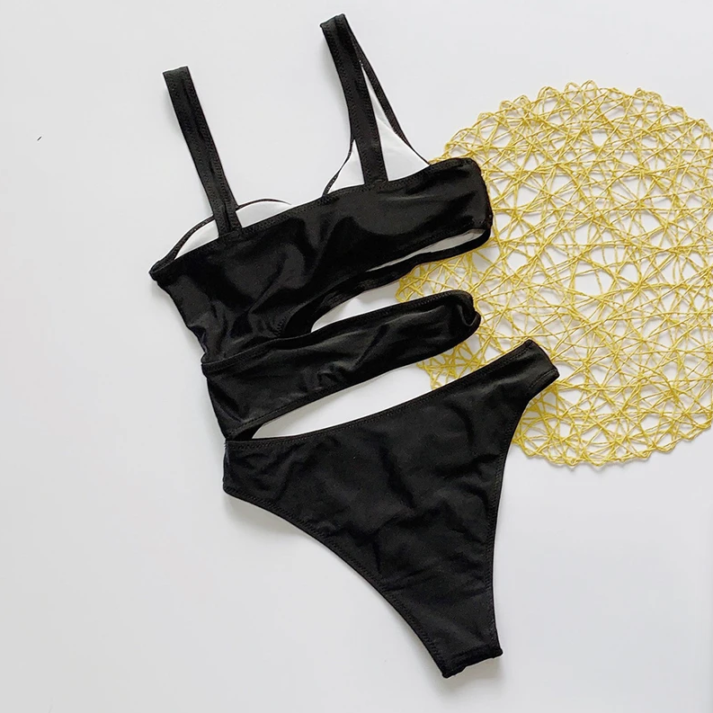 Black bikini set on a white background with a yellow doily.
