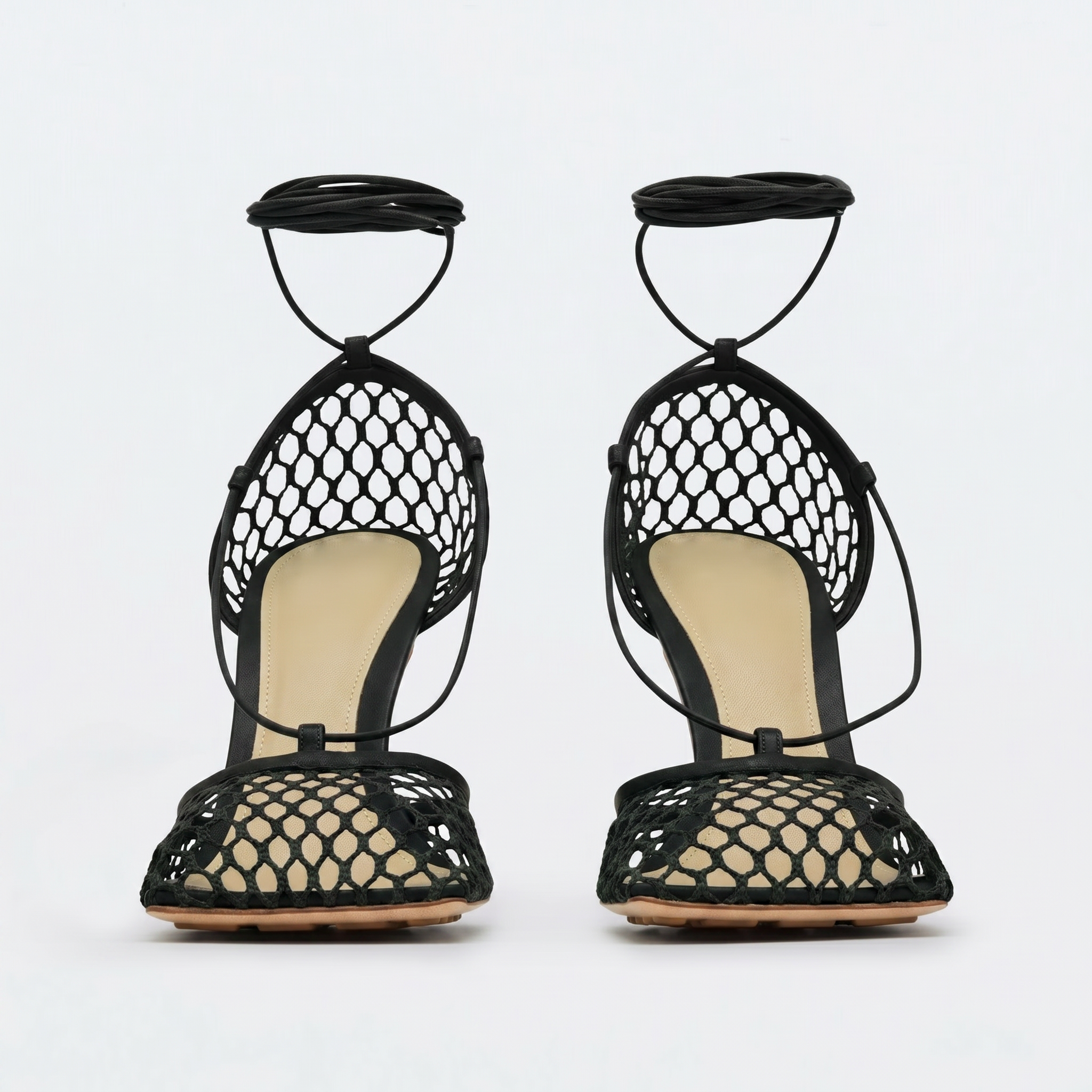 Black fishnet high-heeled sandals on a white background