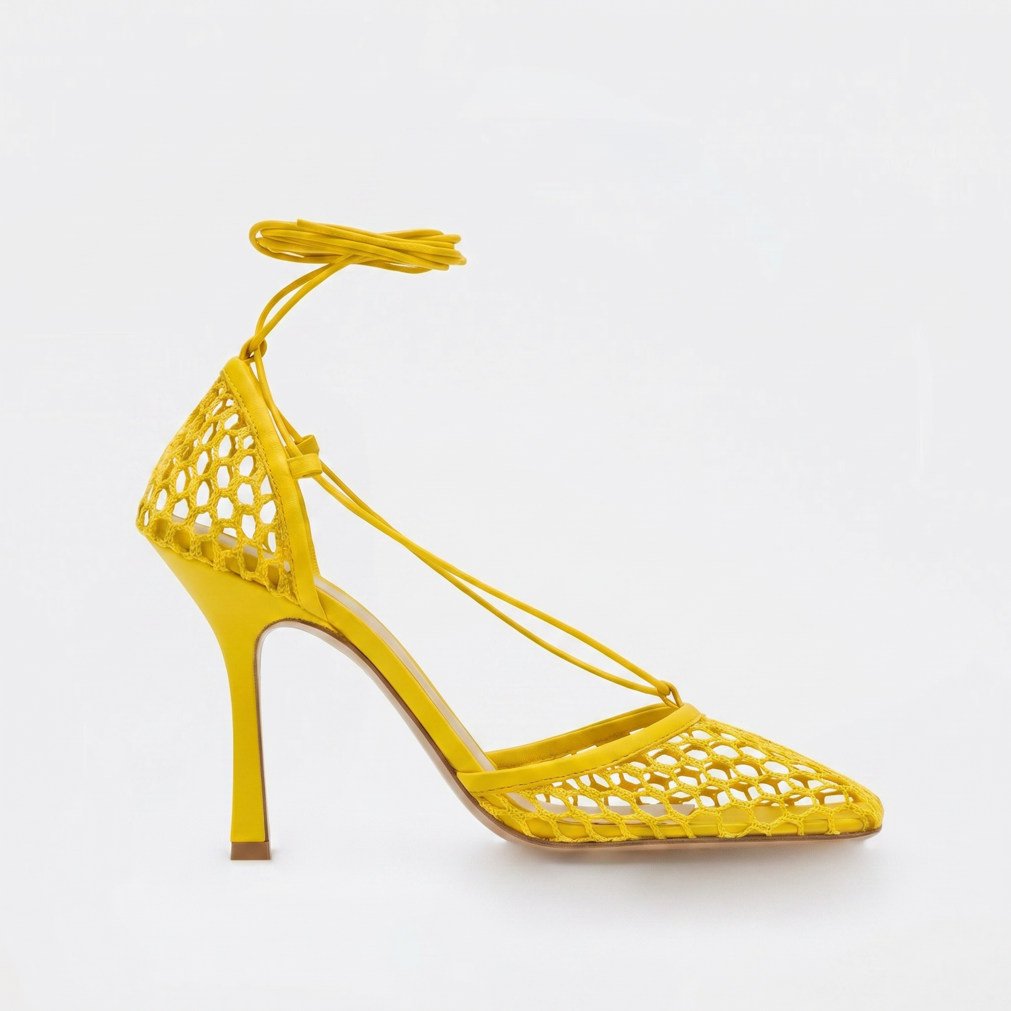 Yellow high-heeled shoe with cut-out design on a white background