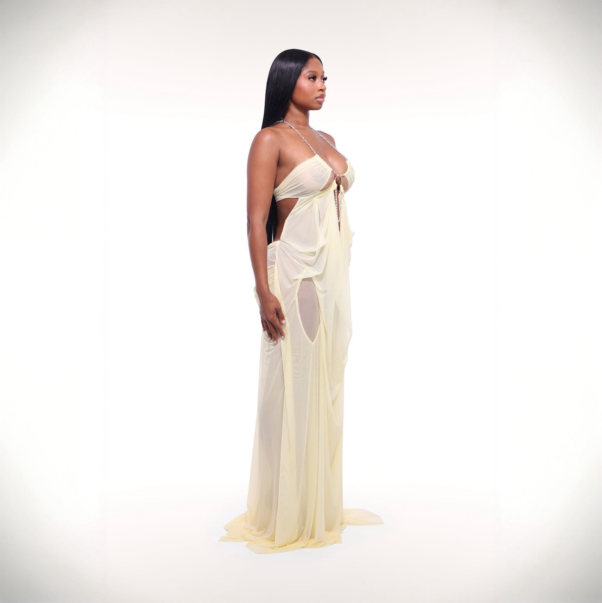 Woman wearing a flowing white dress on a plain background