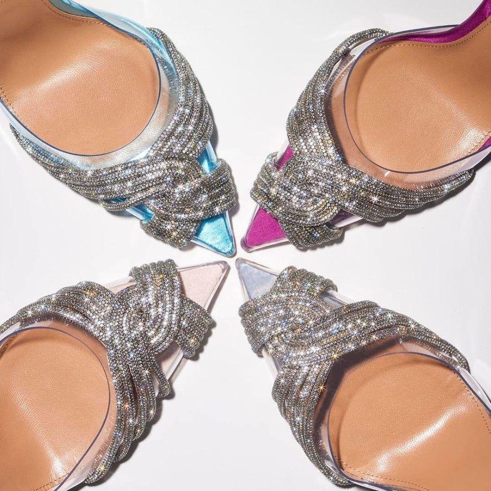Four high-heeled shoes with embellished straps on a white background