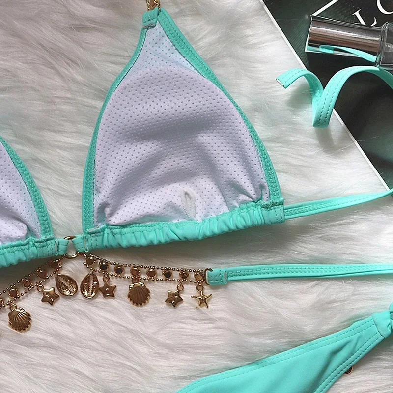 Teal bikini set with charms on a white surface