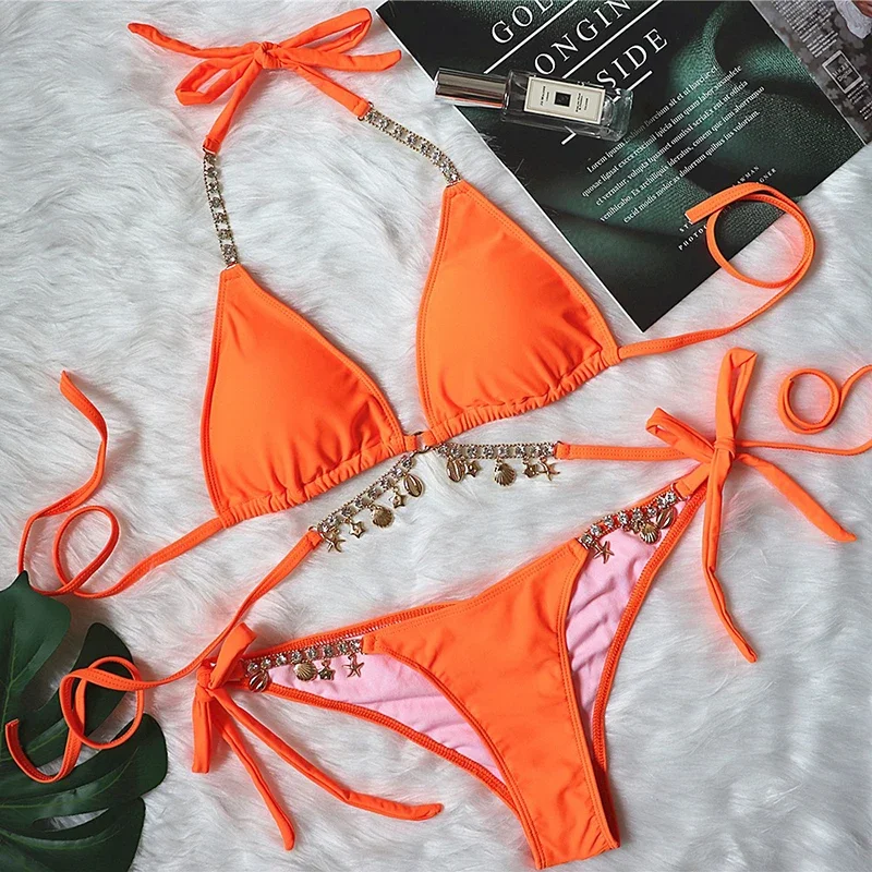 Orange bikini set with decorative elements on a textured surface.