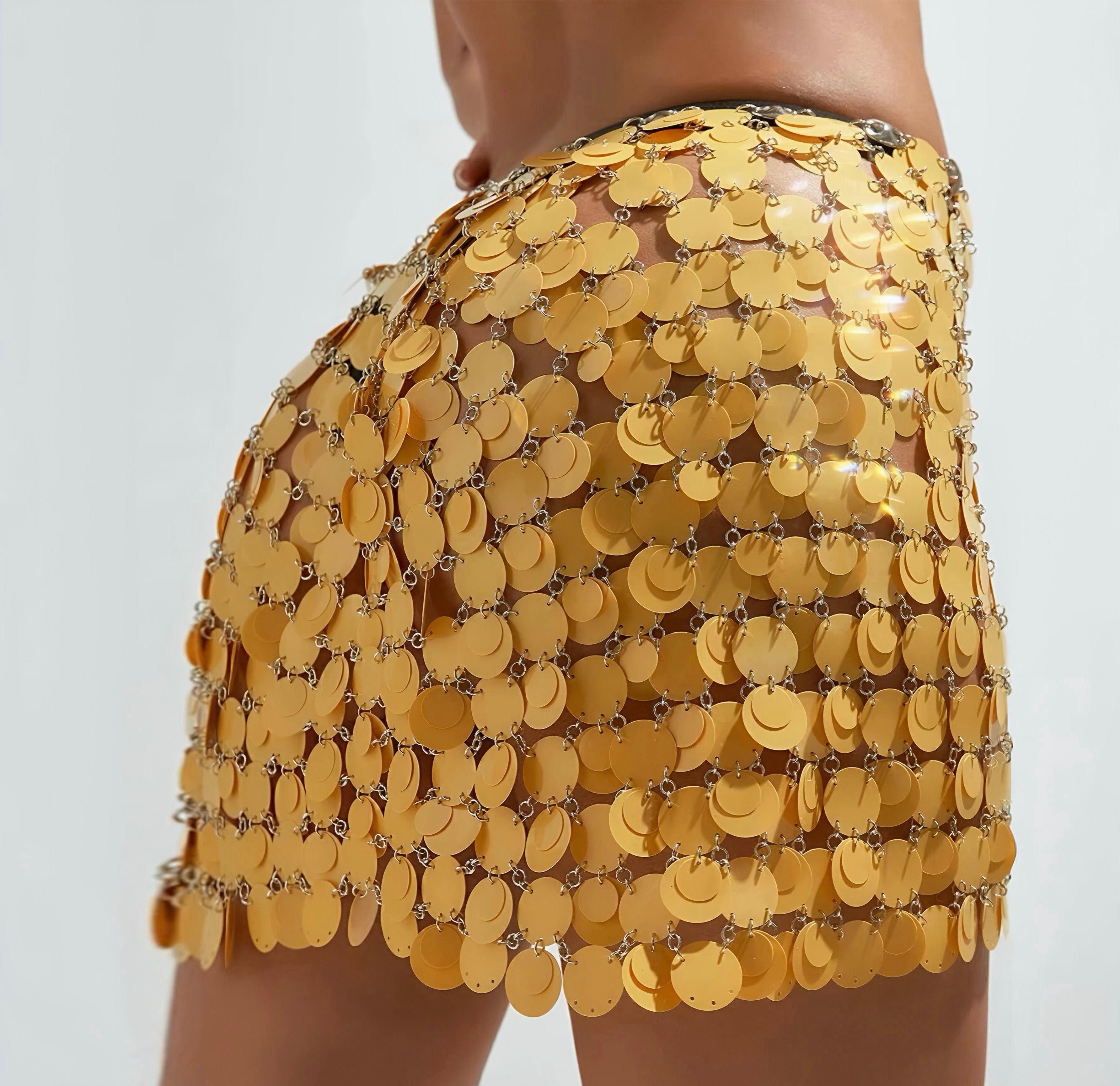 Yellow sequin skirt worn by a person on a plain background