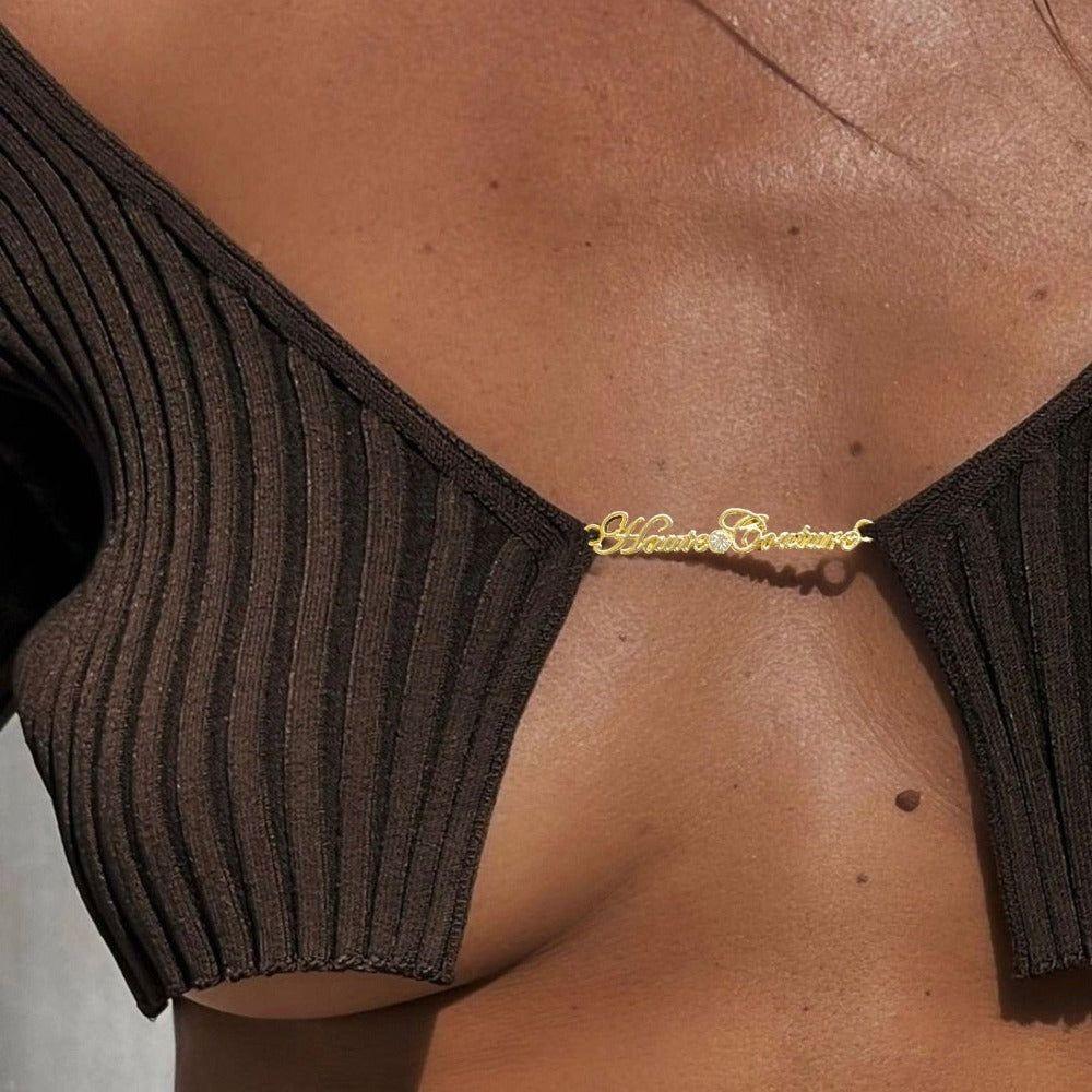 Person wearing a brown top with gold detail against a neutral background