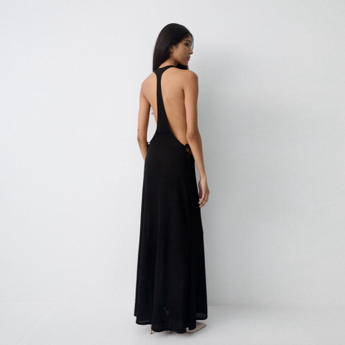 Woman wearing a black halter neck dress on a white background