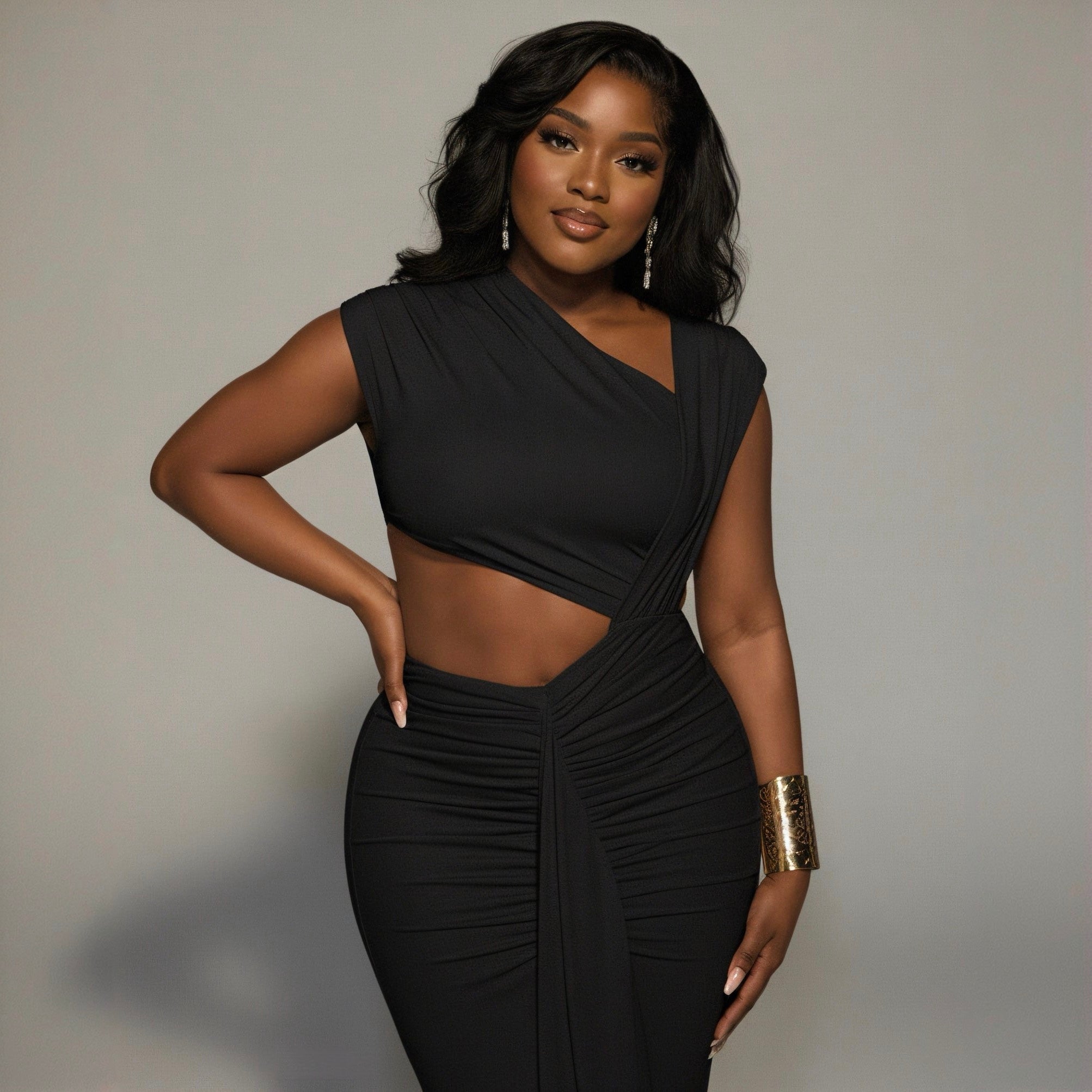 Woman wearing a black dress with cut-out design against a neutral background
