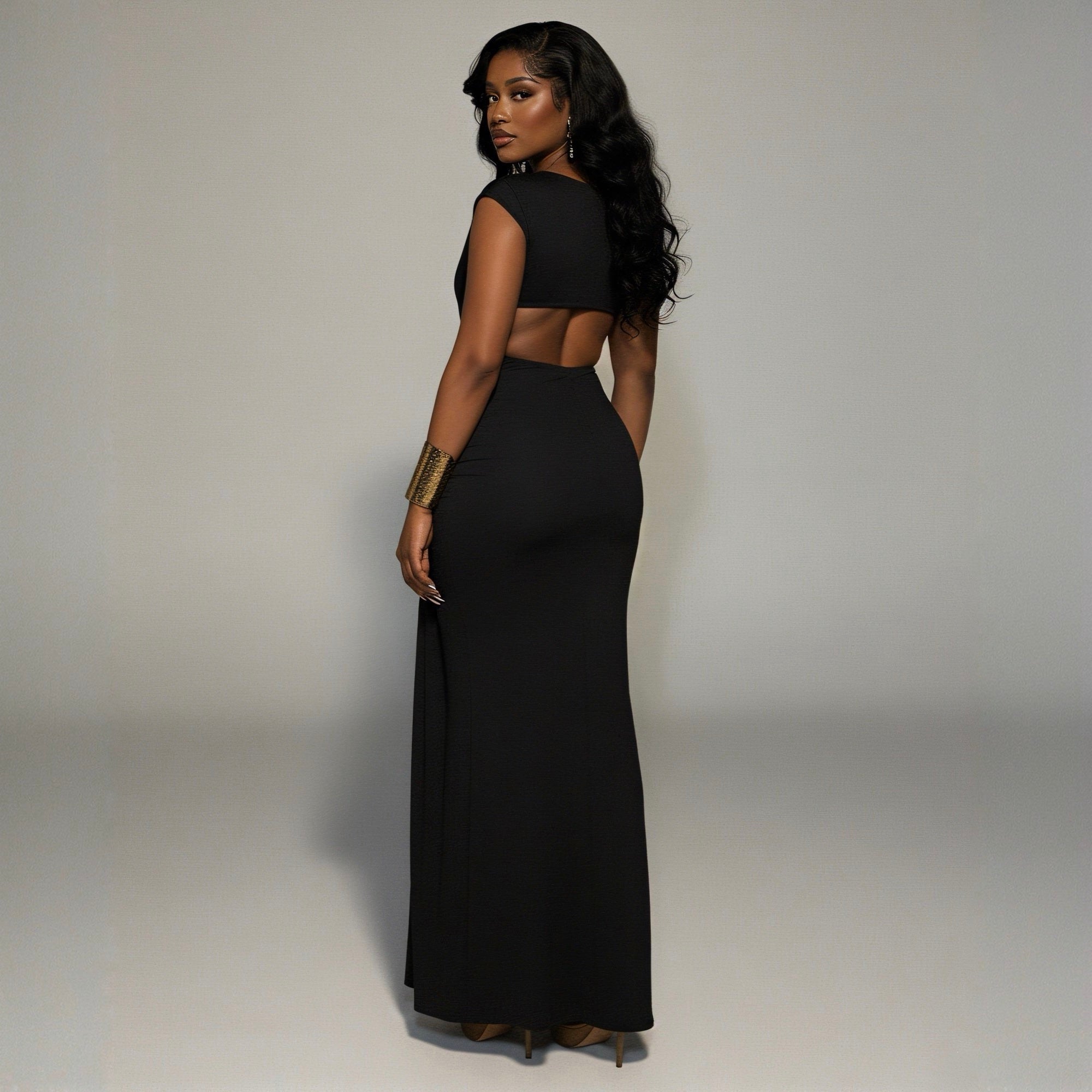Woman wearing a black dress with cut-out design on a plain background
