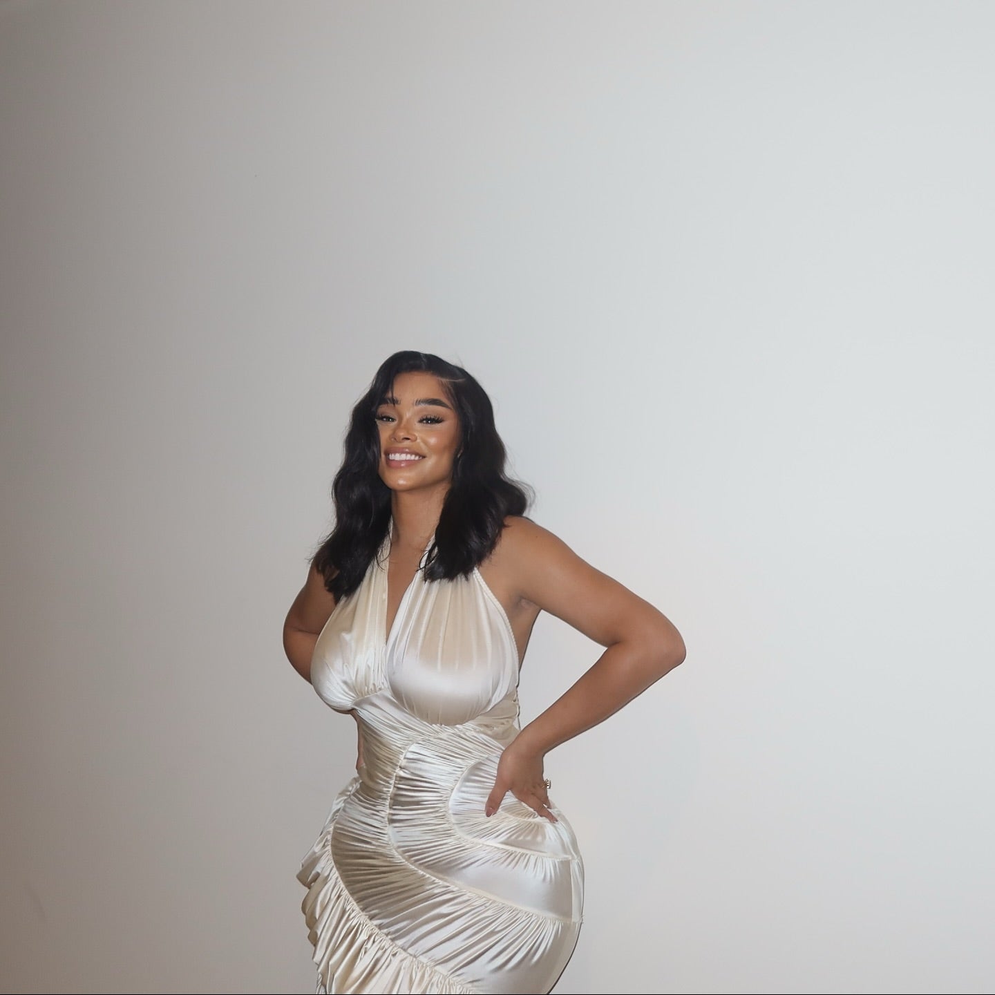 Woman wearing a white dress against a plain background