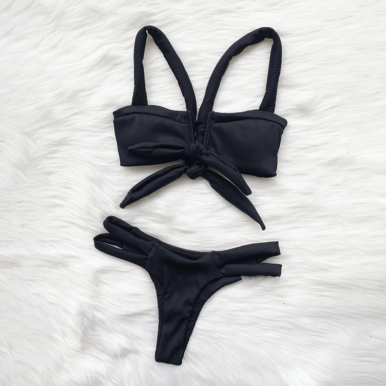Black bikini set on a white textured surface