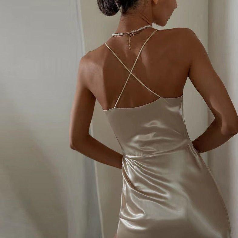 Woman wearing a beige satin slip dress with a neutral background