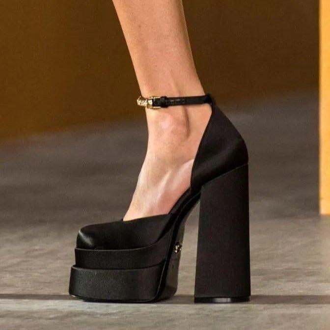 Black platform high-heeled shoe on a neutral background