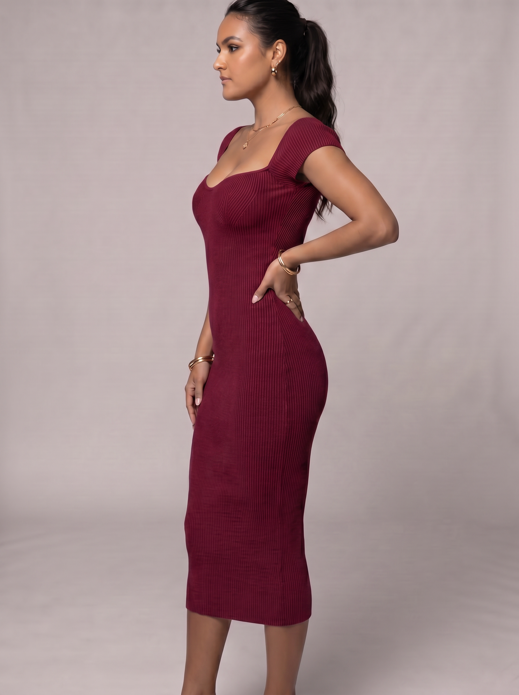 Woman wearing a burgundy dress against a plain background