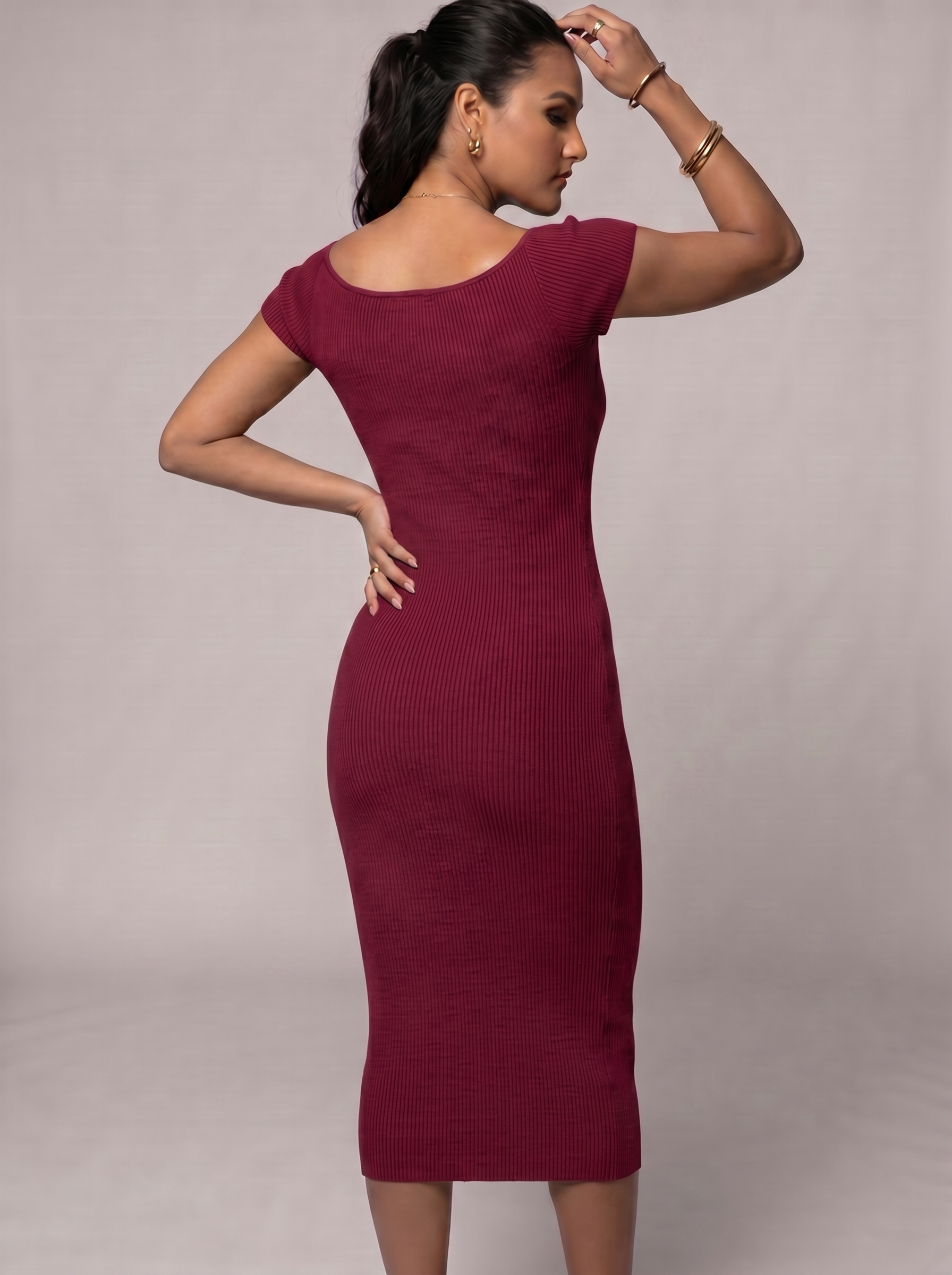 Woman wearing a burgundy dress against a plain background