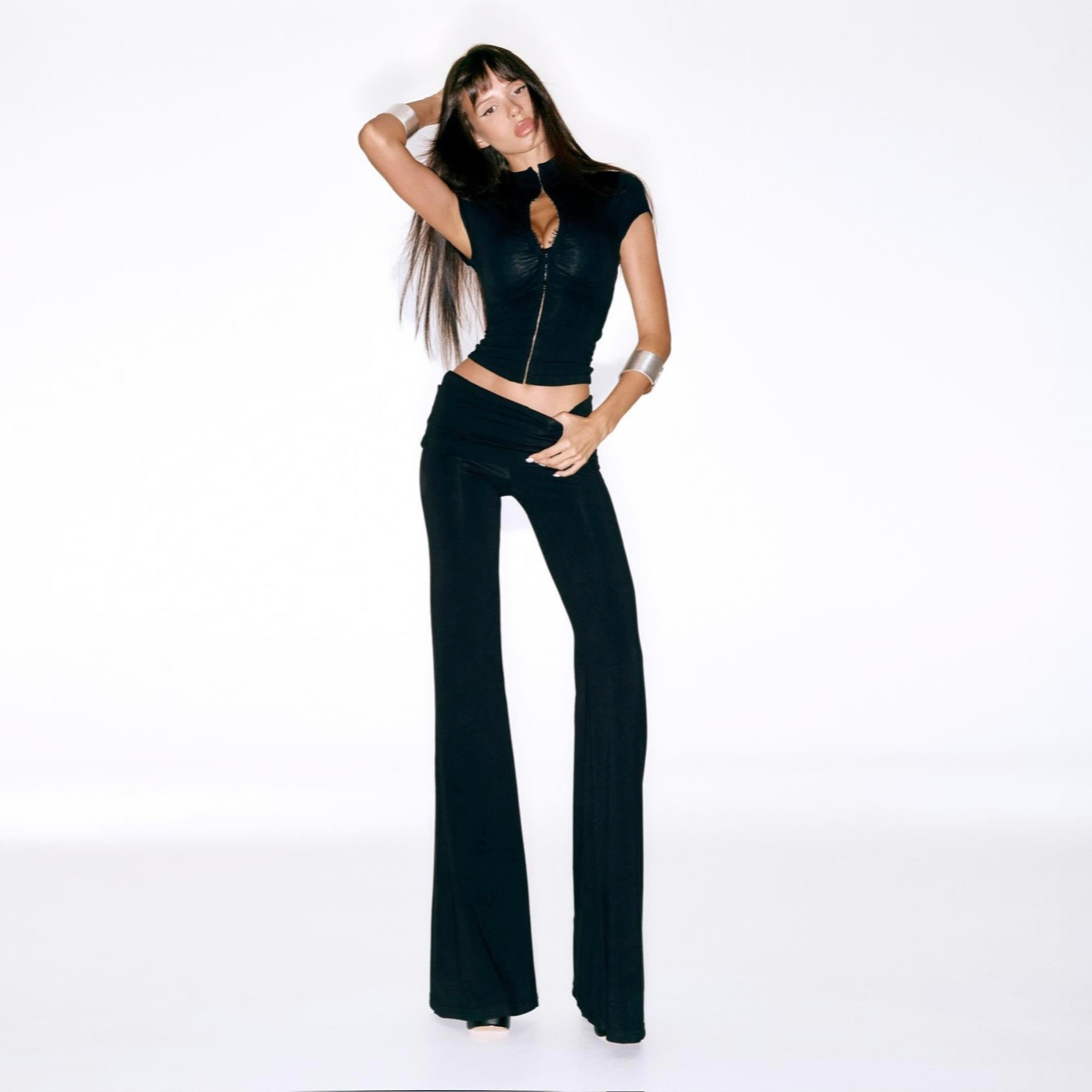 Woman wearing a black outfit with a cut-out design on a white background