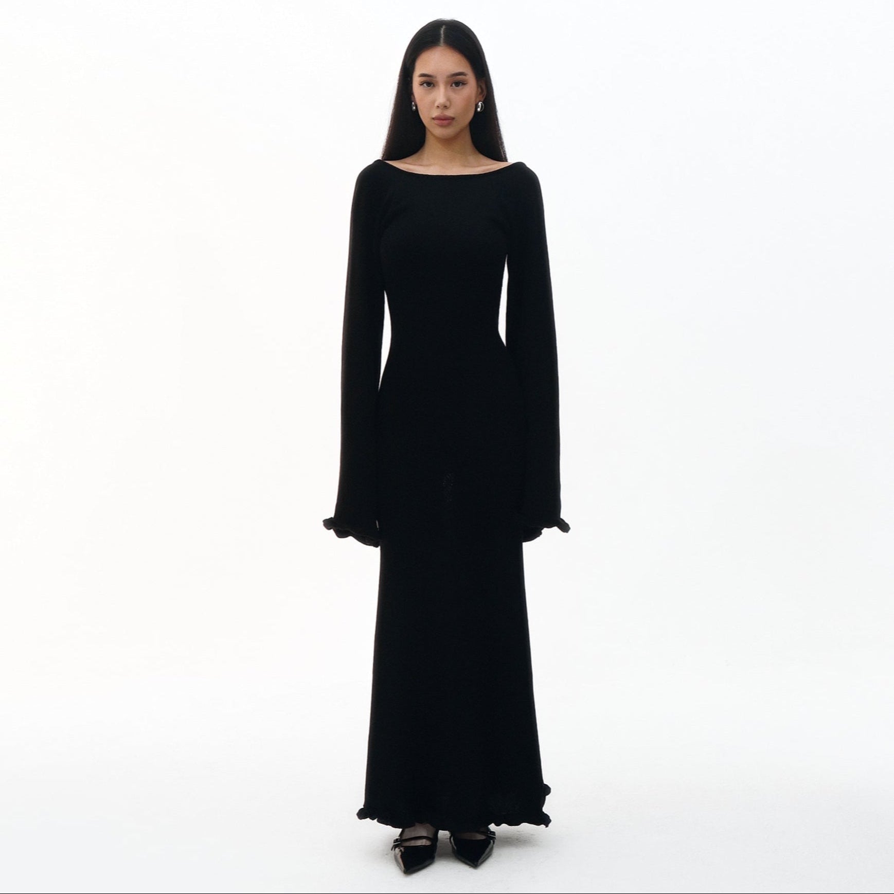 Black long-sleeve dress worn by a model on a white background