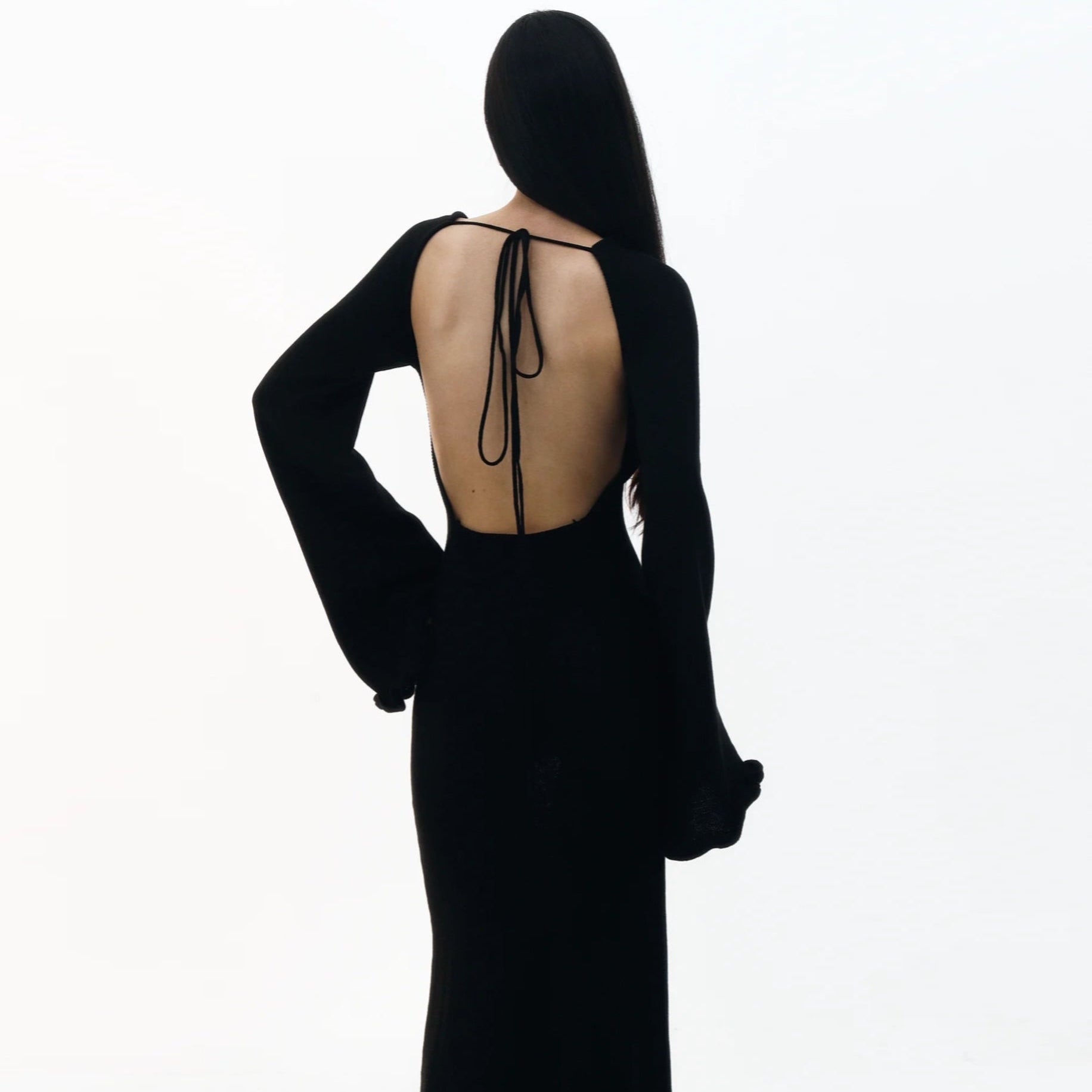 Black dress with open back on a white background