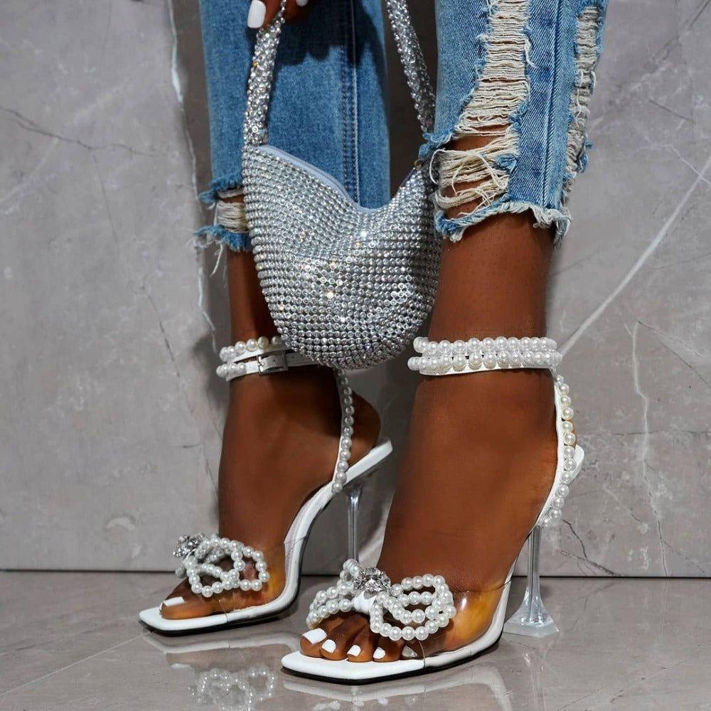 High-heeled sandals with pearl and crystal embellishments on a neutral background