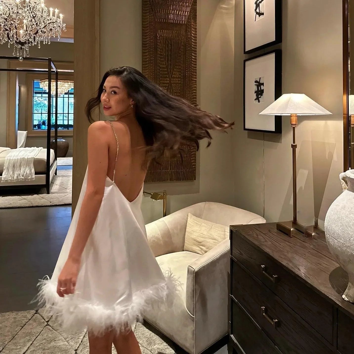 backless white slip dress with feather trim, evening look