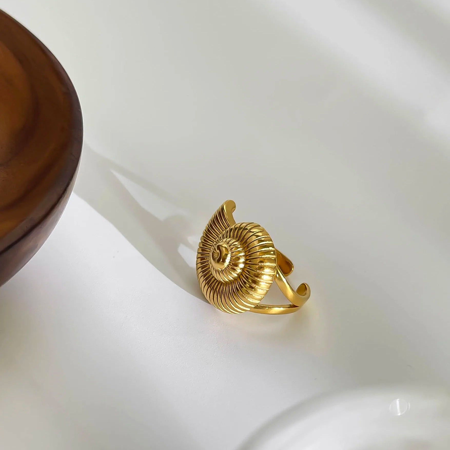 Gold spiral ring with textured design, elegant accessory.