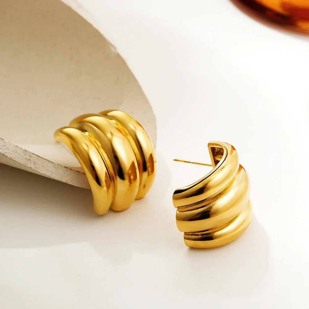 Gold-tone chunky hoop earrings, statement accessory.