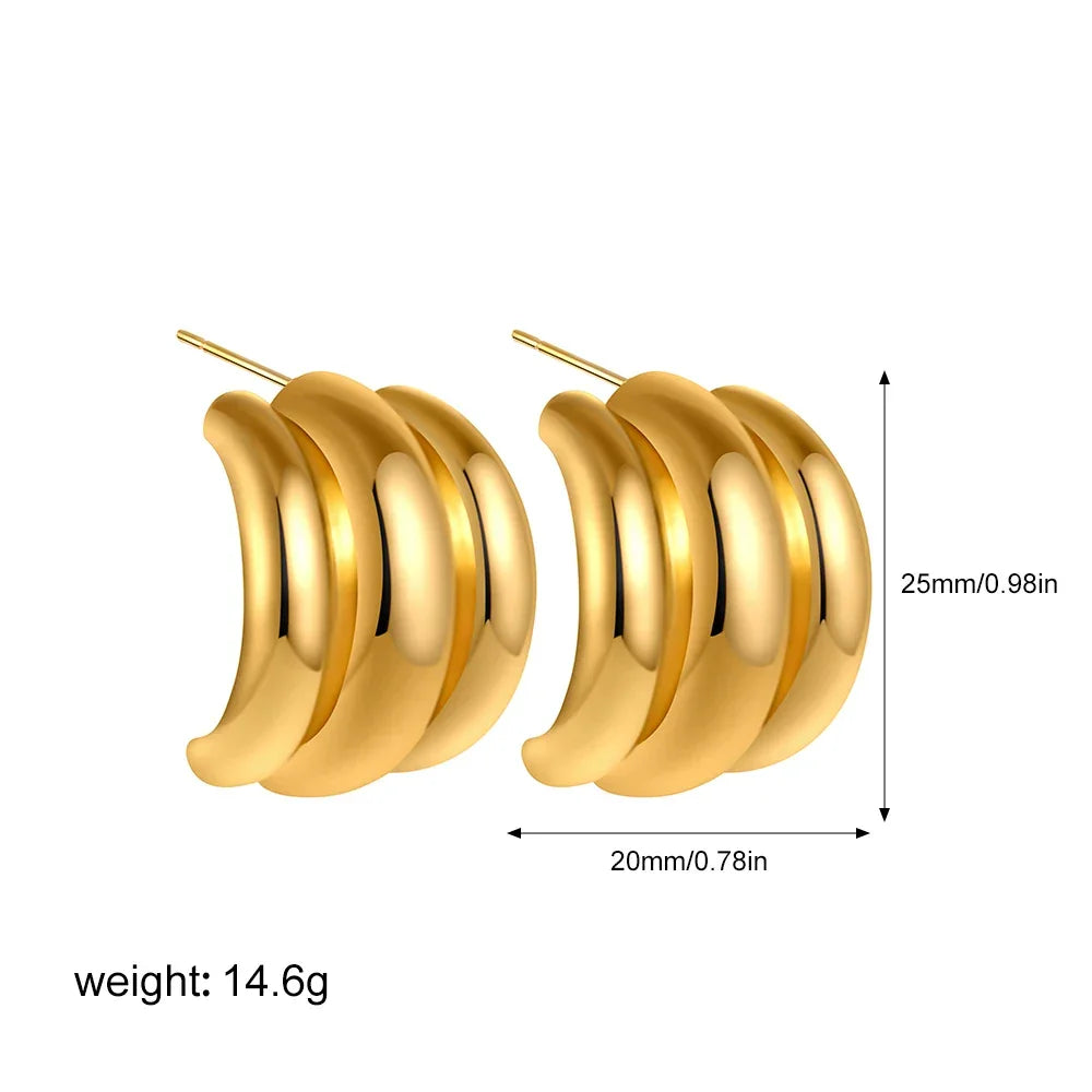 Chunky gold-tone hoop earrings, statement accessory.