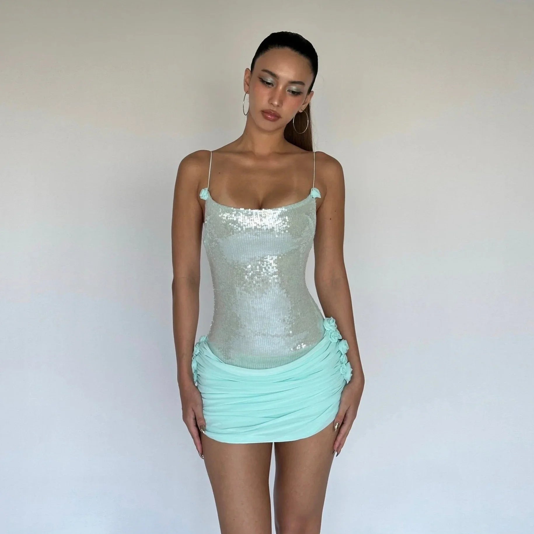 Sequin bodycon mini dress with ruched detailing, party outfit styling.