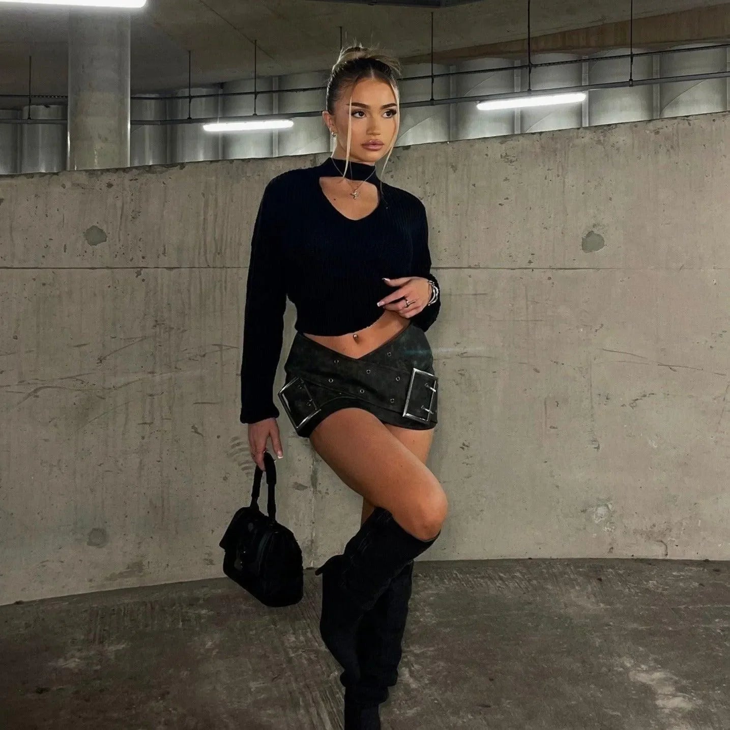 Black cut-out crop top with a belted mini skirt and knee-high boots, edgy night-out lookーpaired