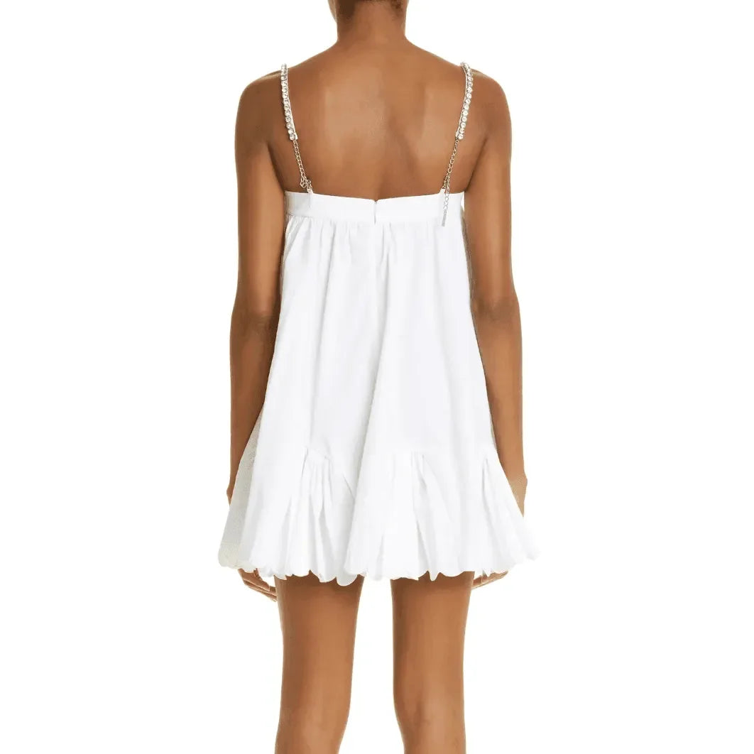 White mini dress with embellishment straps and tiered hem, perfect for day-to-night transition