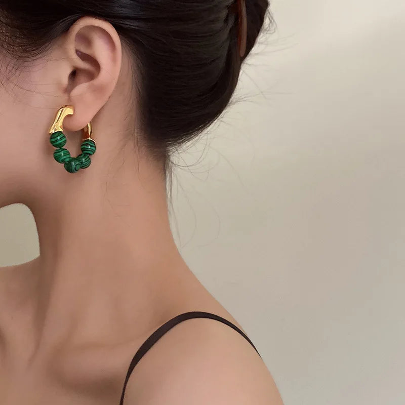 Gold and green beaded hoop earrings, elegant accessory.