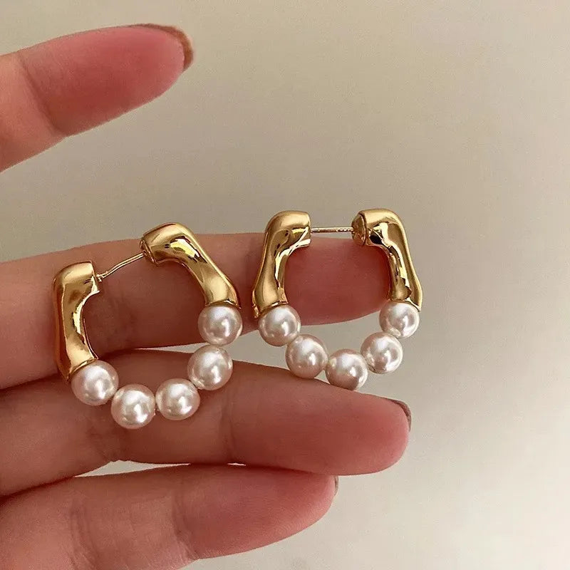 Gold and pearl hoop earrings, elegant accessory.