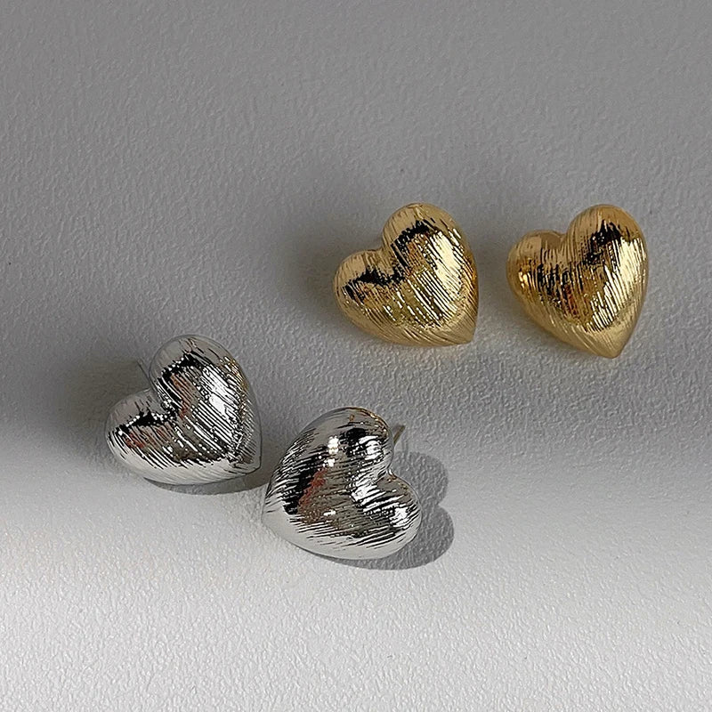 Textured metal heart-shaped stud earrings, silver and gold tones, versatile accessories