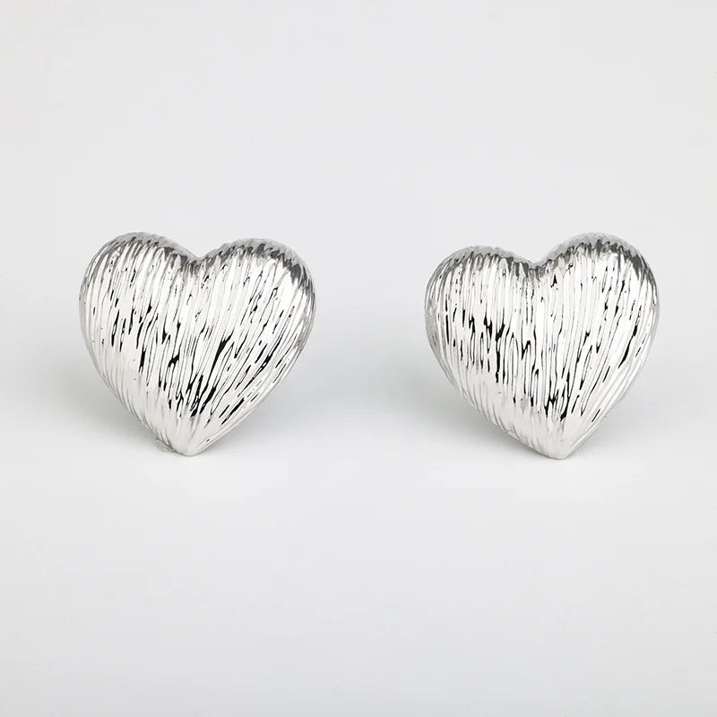 Silver heart-shaped earrings with textured detail, chic accessory for any outfit