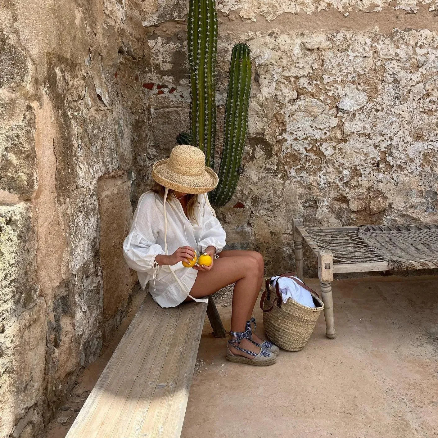 Wide-brim straw hat and oversized white blouse, relaxed summer ensemble