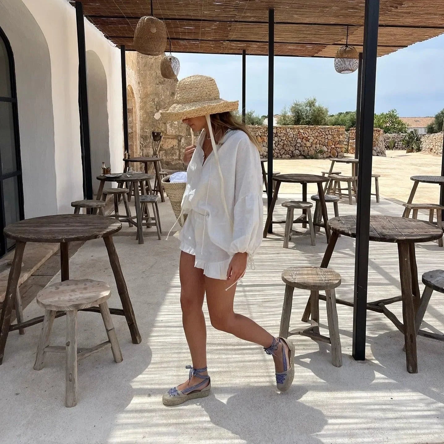 White blouse and shorts with a straw hat and espadrilles, casual look.