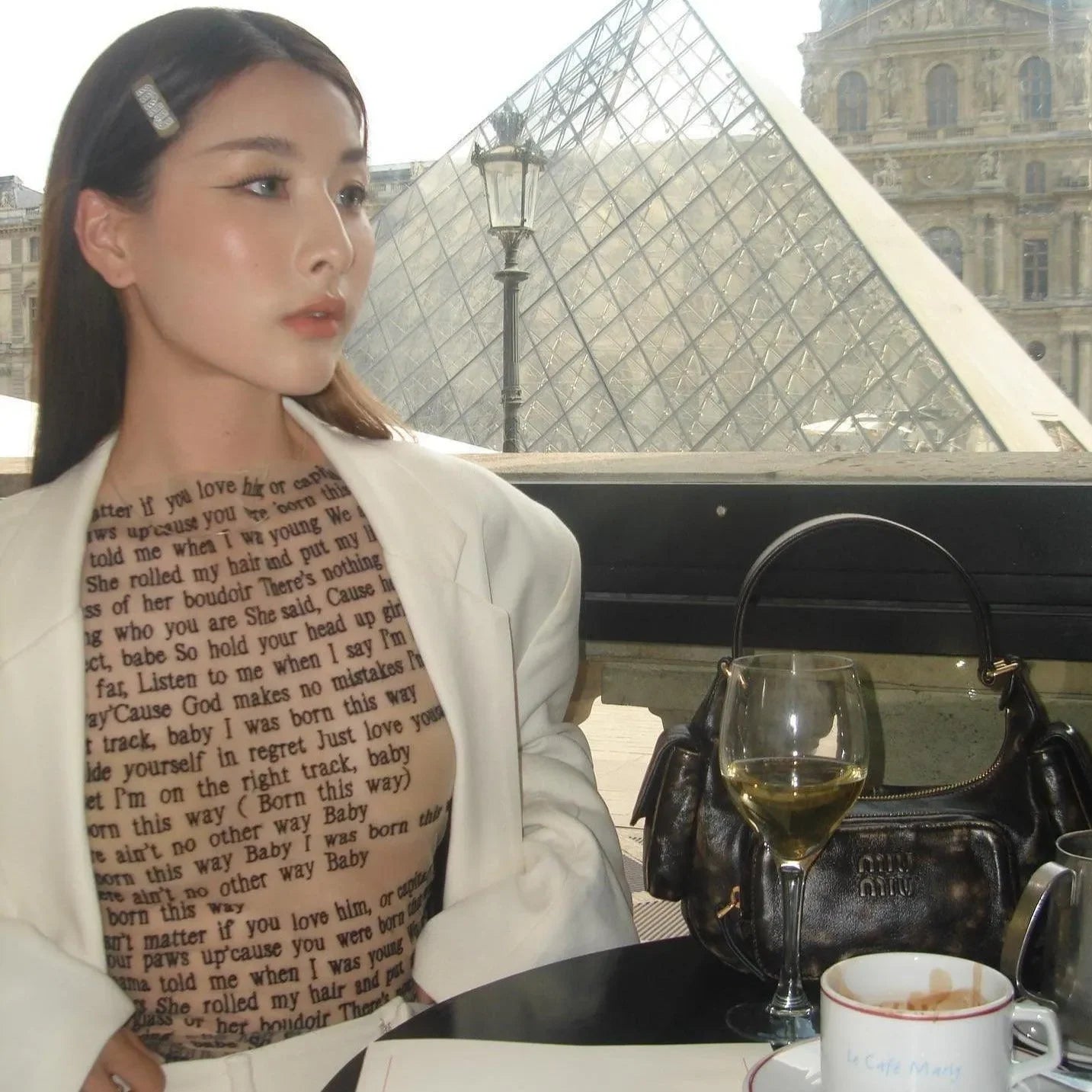 Mesh text-print top layered under white blazer, casual-chic ensemble