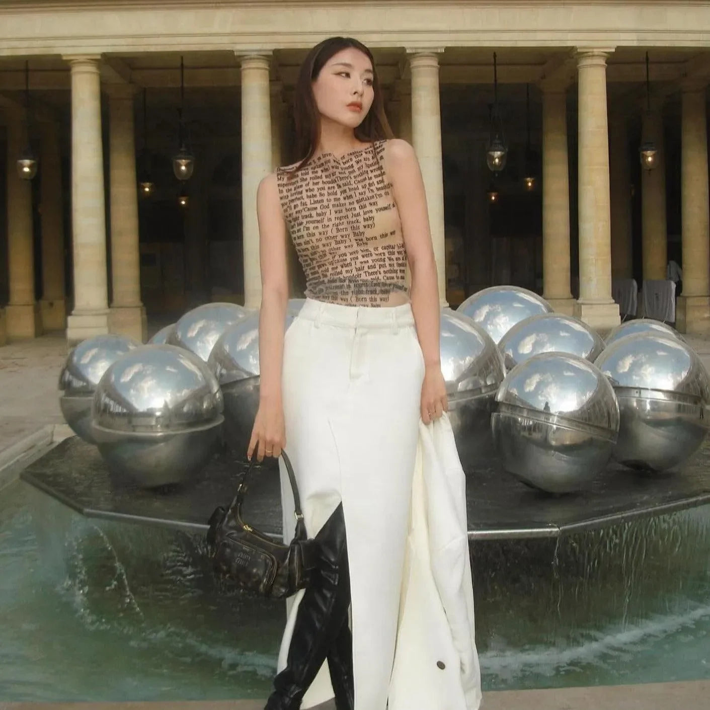Text-print sleeveless top with white high-slit skirt, chic daytime ensemble