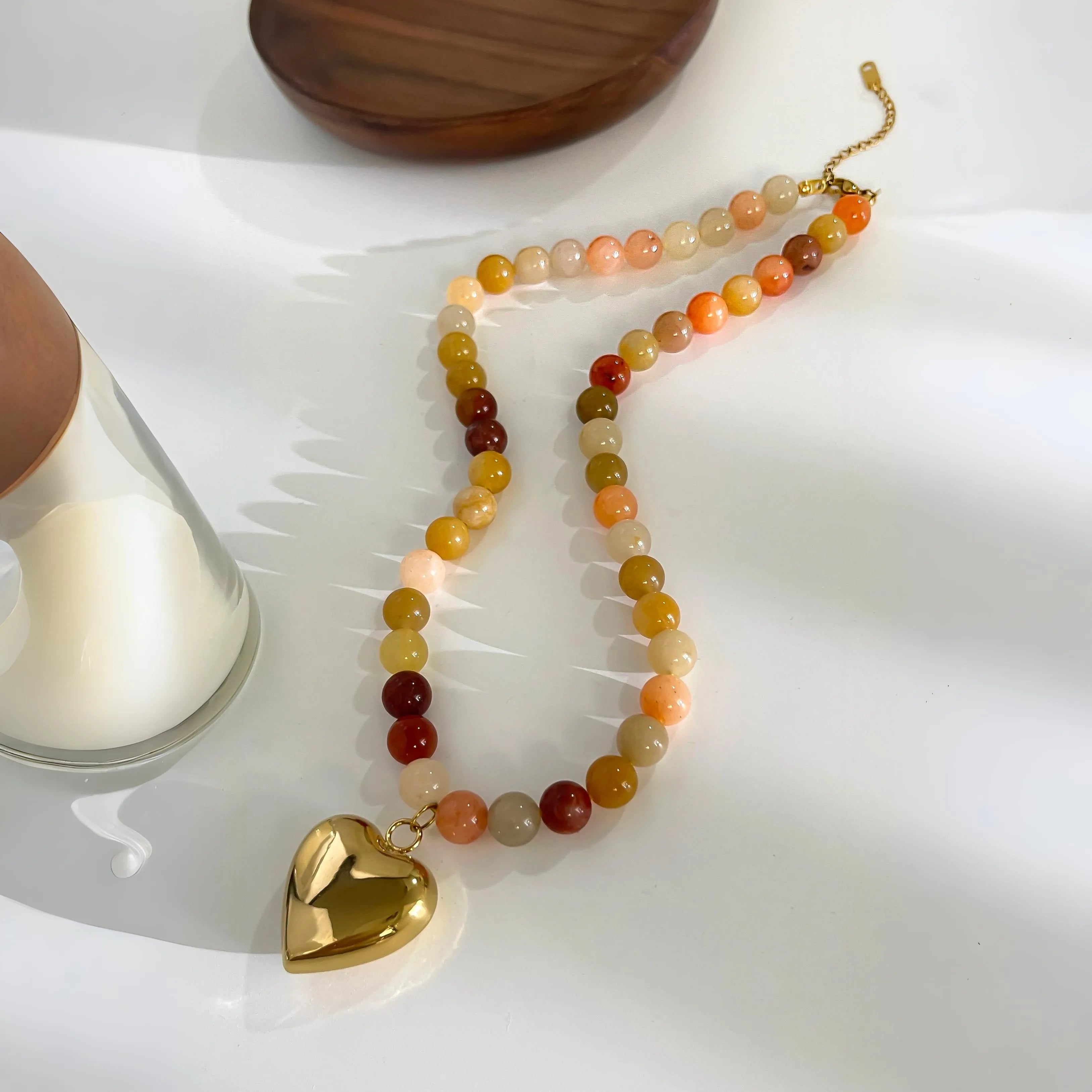 Beaded necklace with multicolor stones and gold heart pendant, stylish accessory.