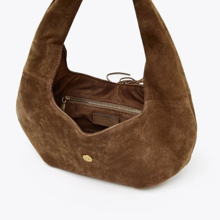 Hobo-style suede handbag with zippered compartment, versatile accessory.