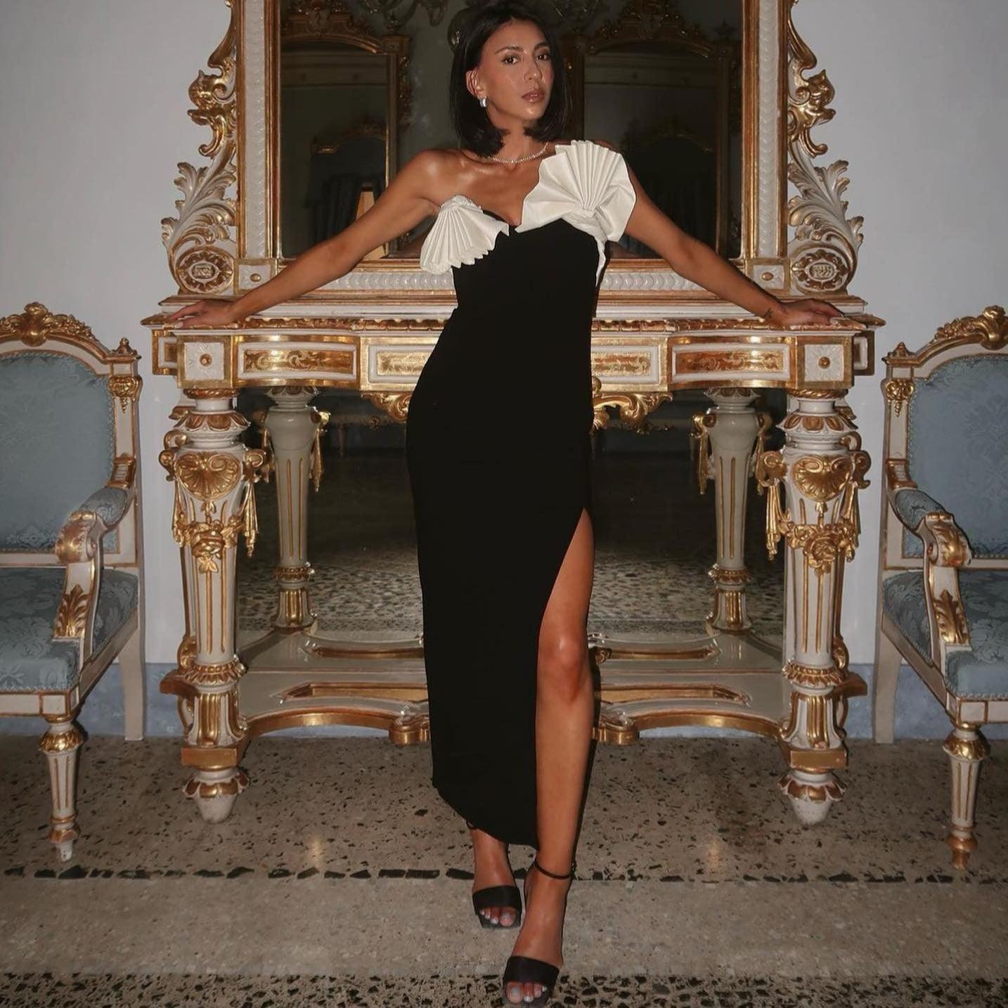 One-shoulder black evening dress with pleated detailing and thigh-high slit.