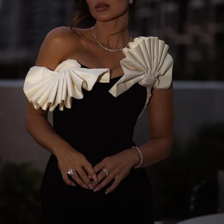 Black evening dress with white sculptural sleeves.