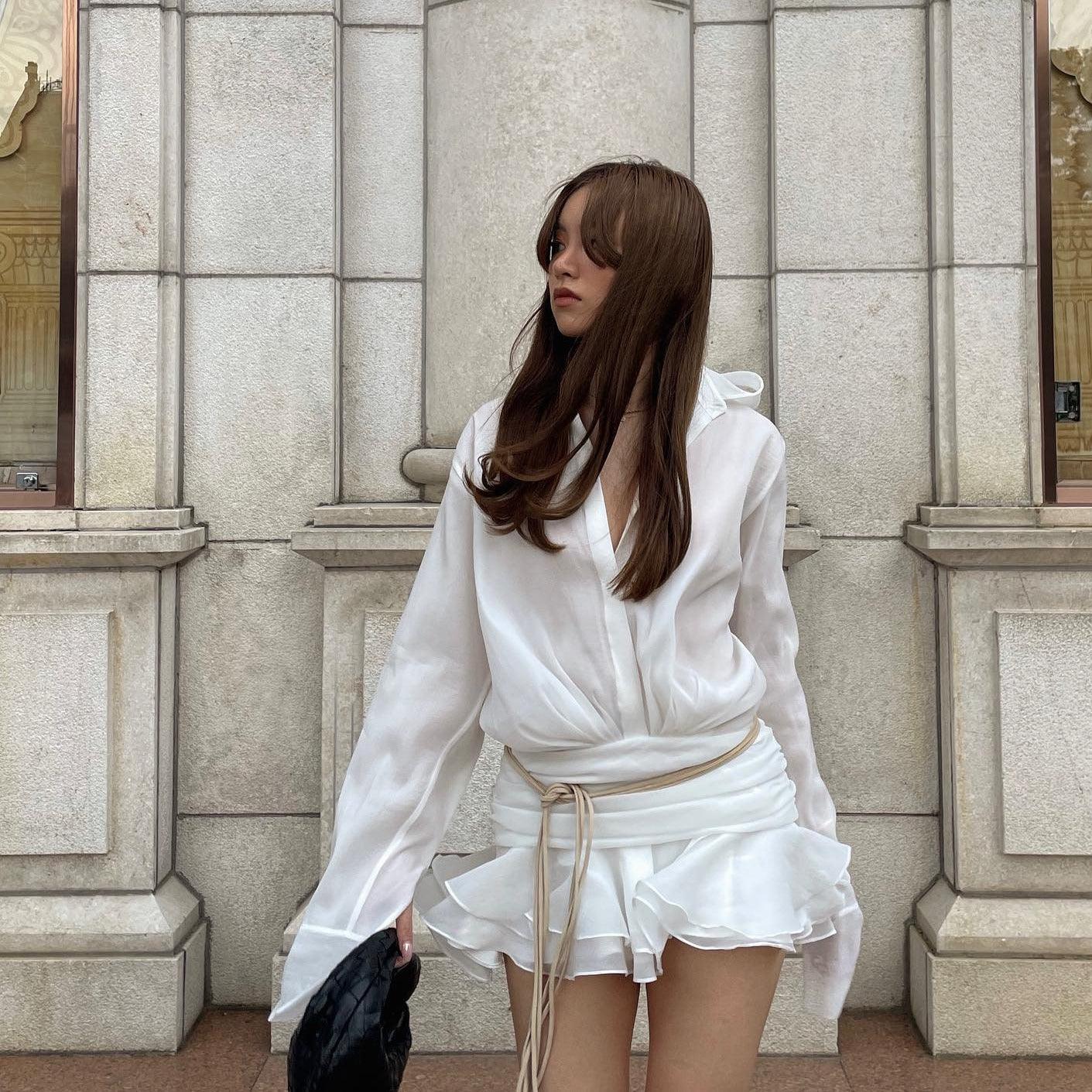 white ruched mini skirt with layered ruffles, paired with oversized blouse