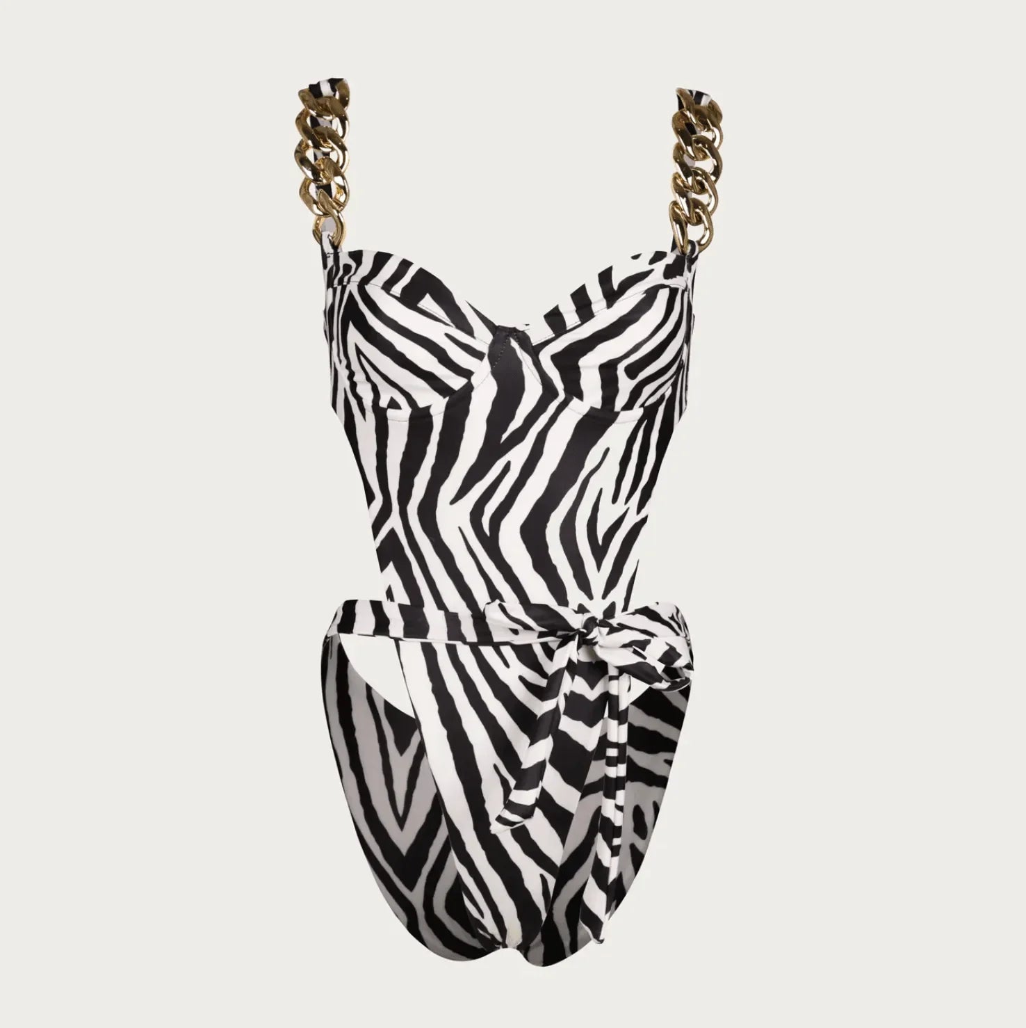 Zebra print one-piece swimsuit with gold chain straps and a tied waist for a chic summer look. Perfect for beach outings.