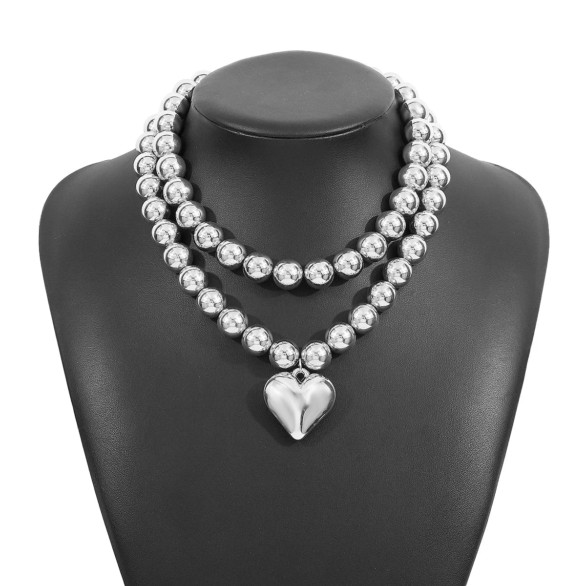 Silver beaded necklace with heart pendant, elegant accessory for evening events.